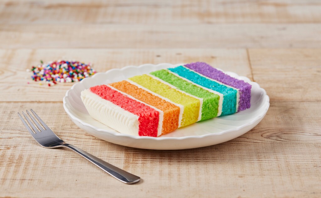 A photo of a slice of rainbow cake